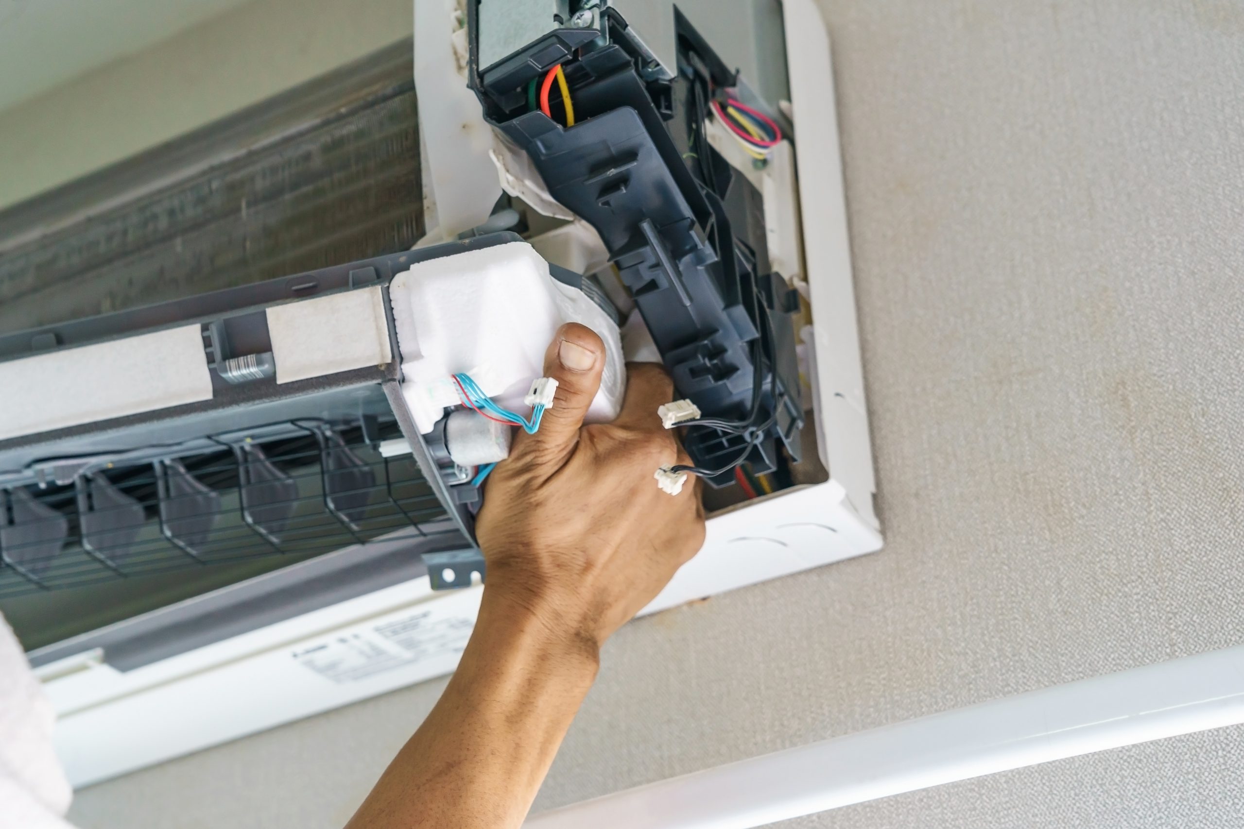 Brown Mechanical technician working on a mini split ductless ac system
